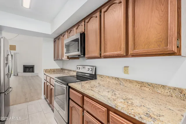 a kitchen with granite countertop a sink a stove and cabinets