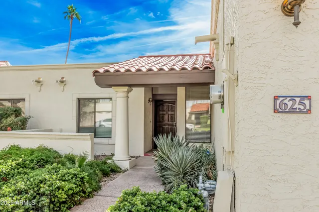 a front view of a house with plants
