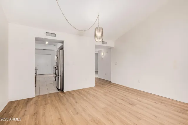 a view of empty room with wooden floor and white walls