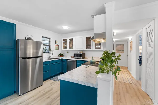 a kitchen with stainless steel appliances a refrigerator sink and wooden floor