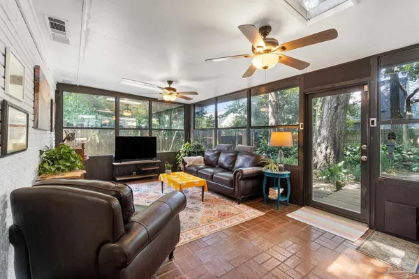 a living room with furniture a flat screen tv and a large window