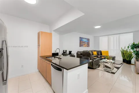 a kitchen with stainless steel appliances kitchen island granite countertop a sink and a refrigerator