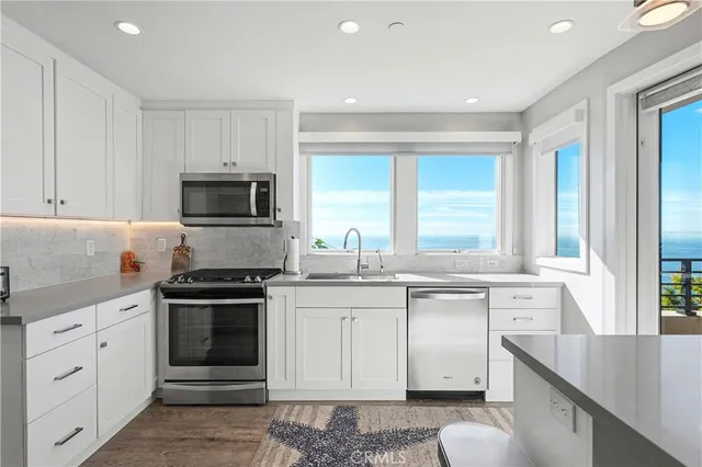 a kitchen with stainless steel appliances granite countertop a sink stove and cabinets