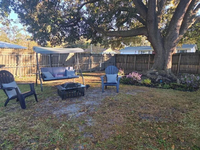 a backyard of a house with barbeque oven table and chairs