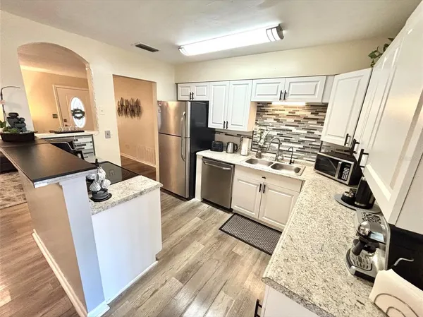 a kitchen with stainless steel appliances kitchen island granite countertop a refrigerator stove and sink