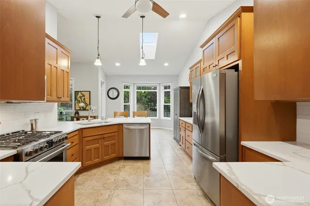 a kitchen with a sink a counter top space stainless steel appliances and cabinets