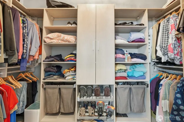 a view of walk in closet with clothes and shoes
