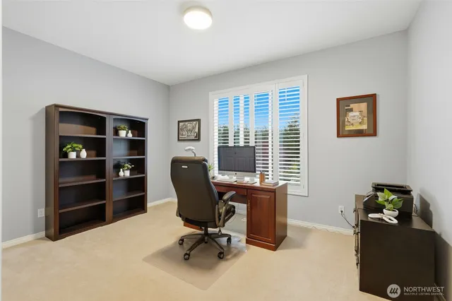 a view of a workspace with furniture and a window