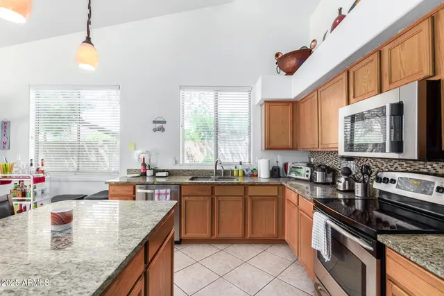 a kitchen with stainless steel appliances granite countertop a sink stove and cabinets