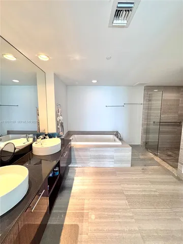 a spacious bathroom with a tub sink and mirror