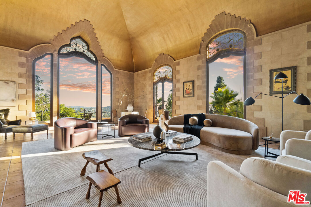 a living room with couches a fireplace and four windows