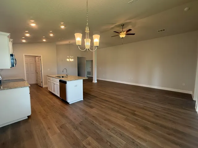 a view of a kitchen with sink microwave and wooden floor