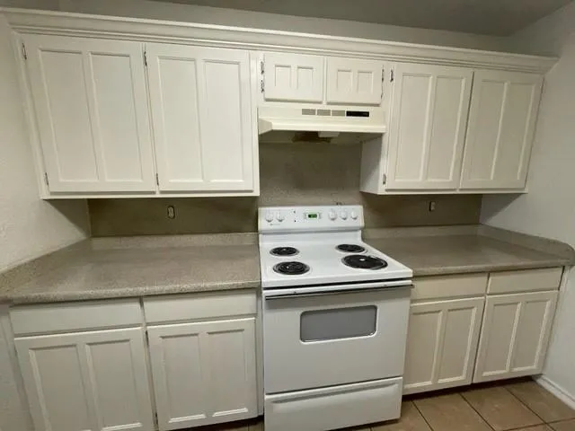 a kitchen with white cabinets and white appliances