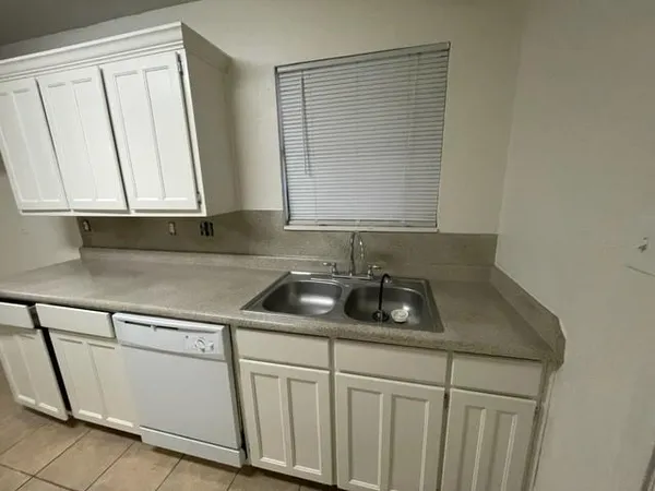 a kitchen with white cabinets and a sink