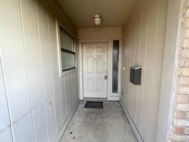 a view of a hallway with wooden floor and closet
