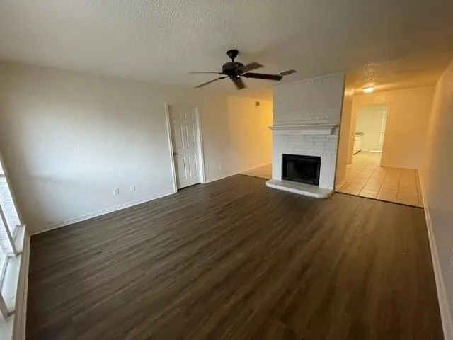 a view of empty room with wooden floor and fireplace