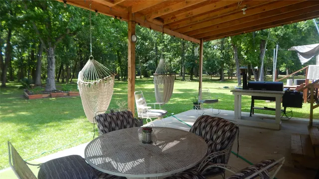 a view of a patio with a table chairs and a backyard