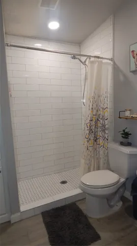 a bathroom with a shower a toilet and a shower