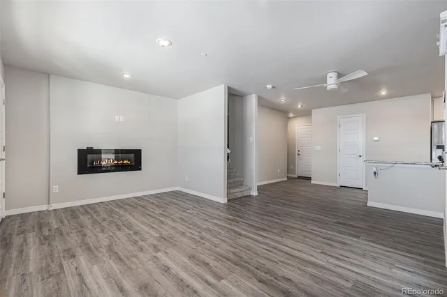 a view of an empty room with wooden floor and a painting