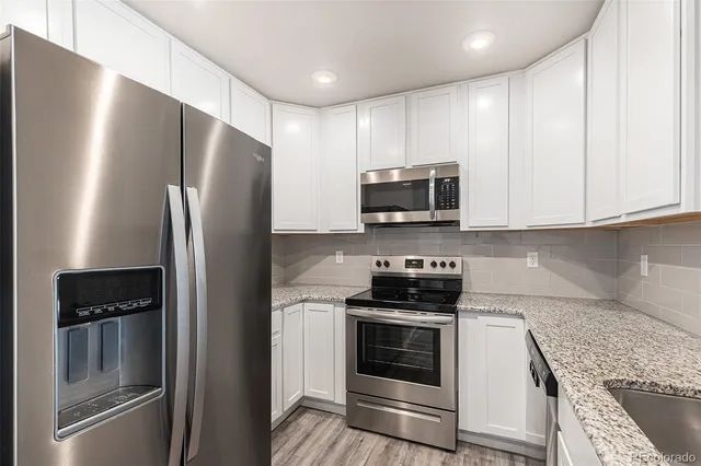 a kitchen with stainless steel appliances granite countertop a refrigerator stove and microwave