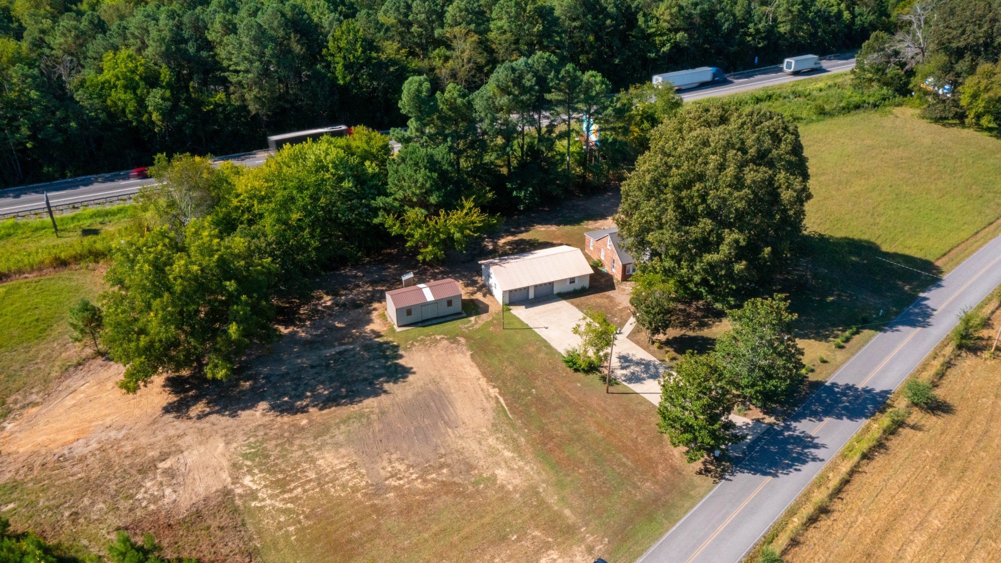 1210 Garton Road Burns, TN 37029 - Photo 11 of 34 a view of a garden with lawn chairs under an umbrella