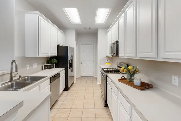 a view of kitchen with cabinets microwave and stove