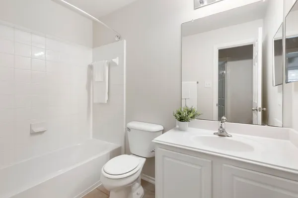a bathroom with a tub a sink and mirror