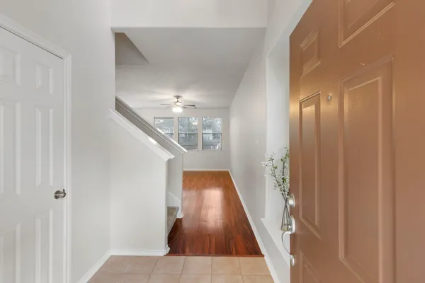 a view of a hallway with wooden floor and staircase