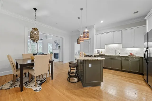 a kitchen with a table chairs a sink dishwasher and cabinets