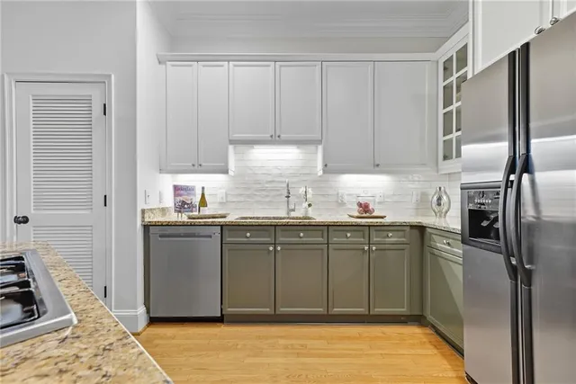 a kitchen with granite countertop a refrigerator sink and cabinets