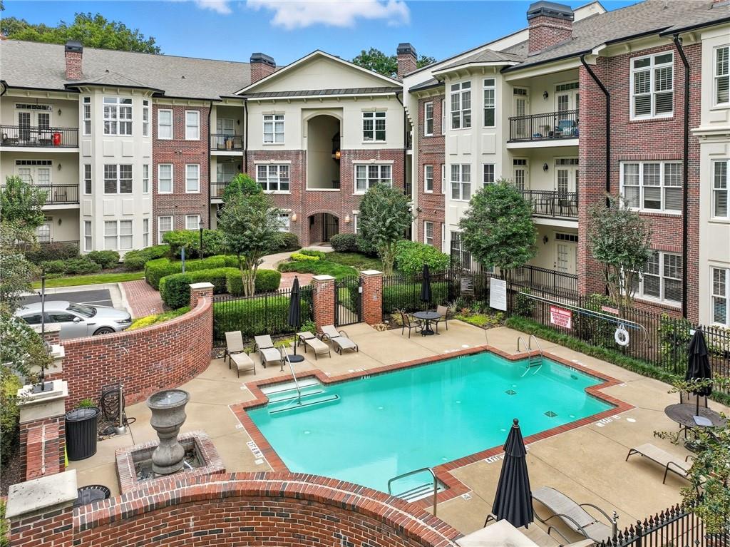 825 Highland Lane Northeast, Unit 1312 Atlanta, GA 30306 - Photo 2 of 46 a view of a patio with couches table and chairs under an umbrella