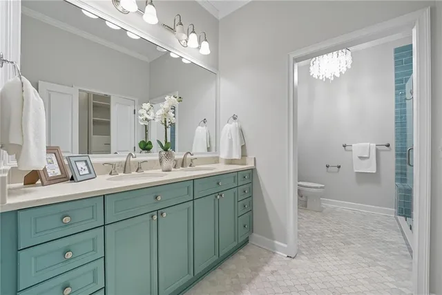 a spacious bathroom with a double vanity sink a toilet and a large mirror