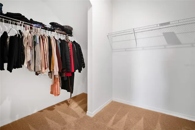 a view of walk in closet with clothes