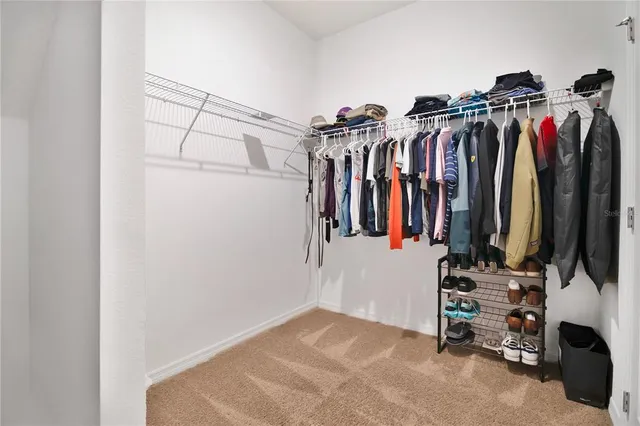 a view of walk in closet with clothes