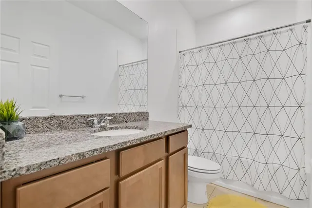 a bathroom with a granite countertop sink and a toilet