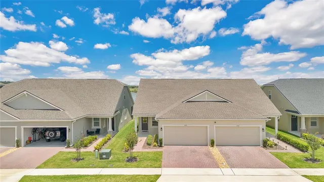 a view of a white house with a yard and potted plants