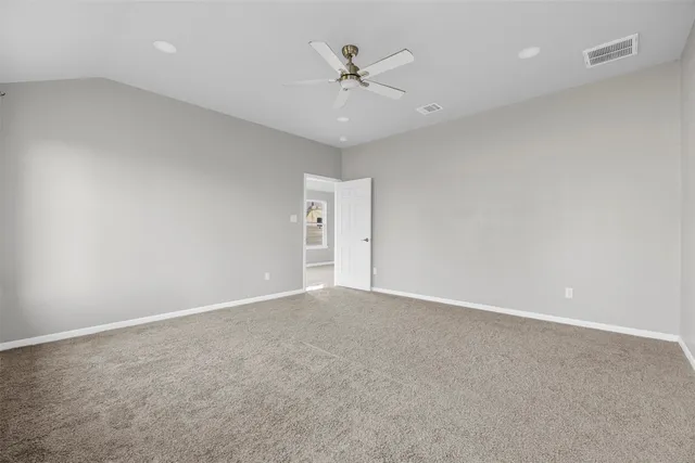 an empty room with a ceiling fan and a window