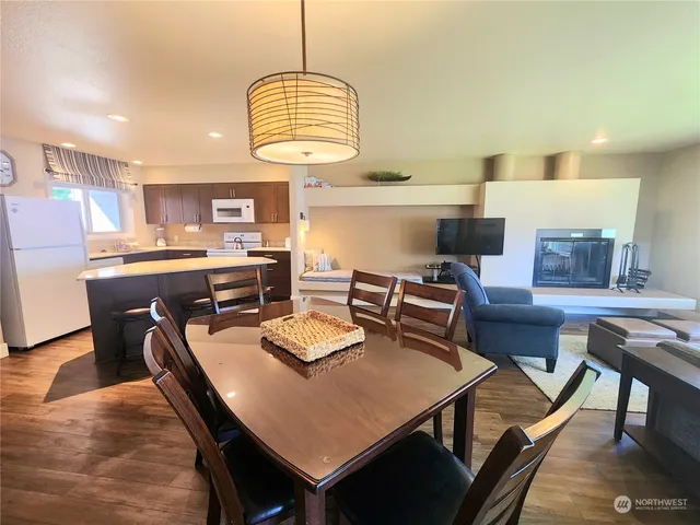a view of a dining room with furniture a chandelier and wooden floor
