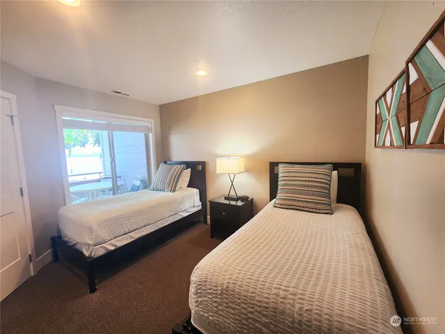 a bedroom with two beds and painting on the wall