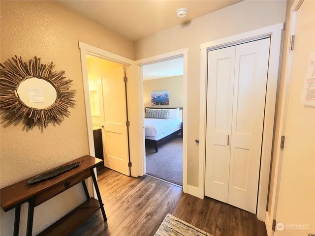 a bedroom with wooden floor and a chandelier