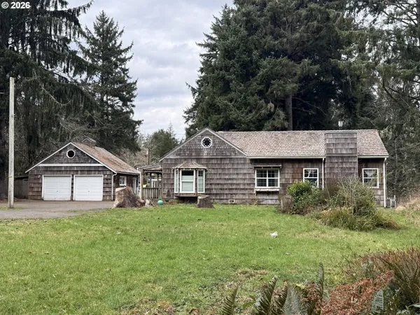 a front view of a house with a garden and trees