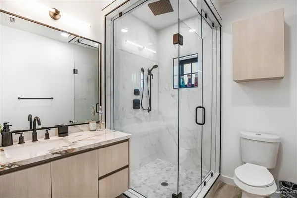 a bathroom with a granite countertop sink toilet and shower