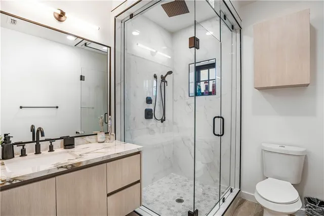 a bathroom with a granite countertop sink toilet and shower