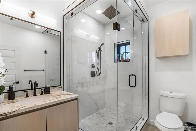 a bathroom with a granite countertop sink toilet and shower