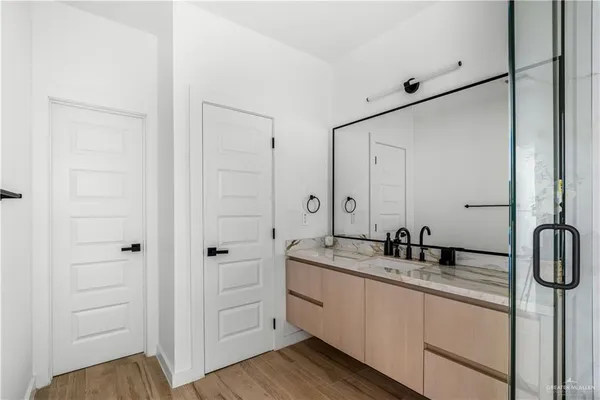 a spacious bathroom with a double vanity sink a mirror and a shower