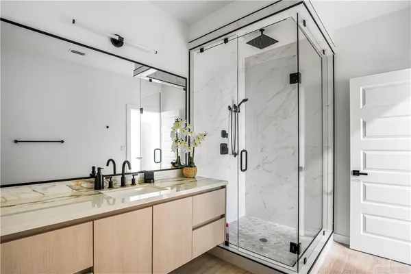 a bathroom with a shower sink and mirror
