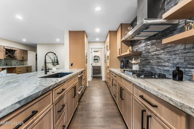 a large kitchen with stainless steel appliances granite countertop a stove a sink and a wooden floors