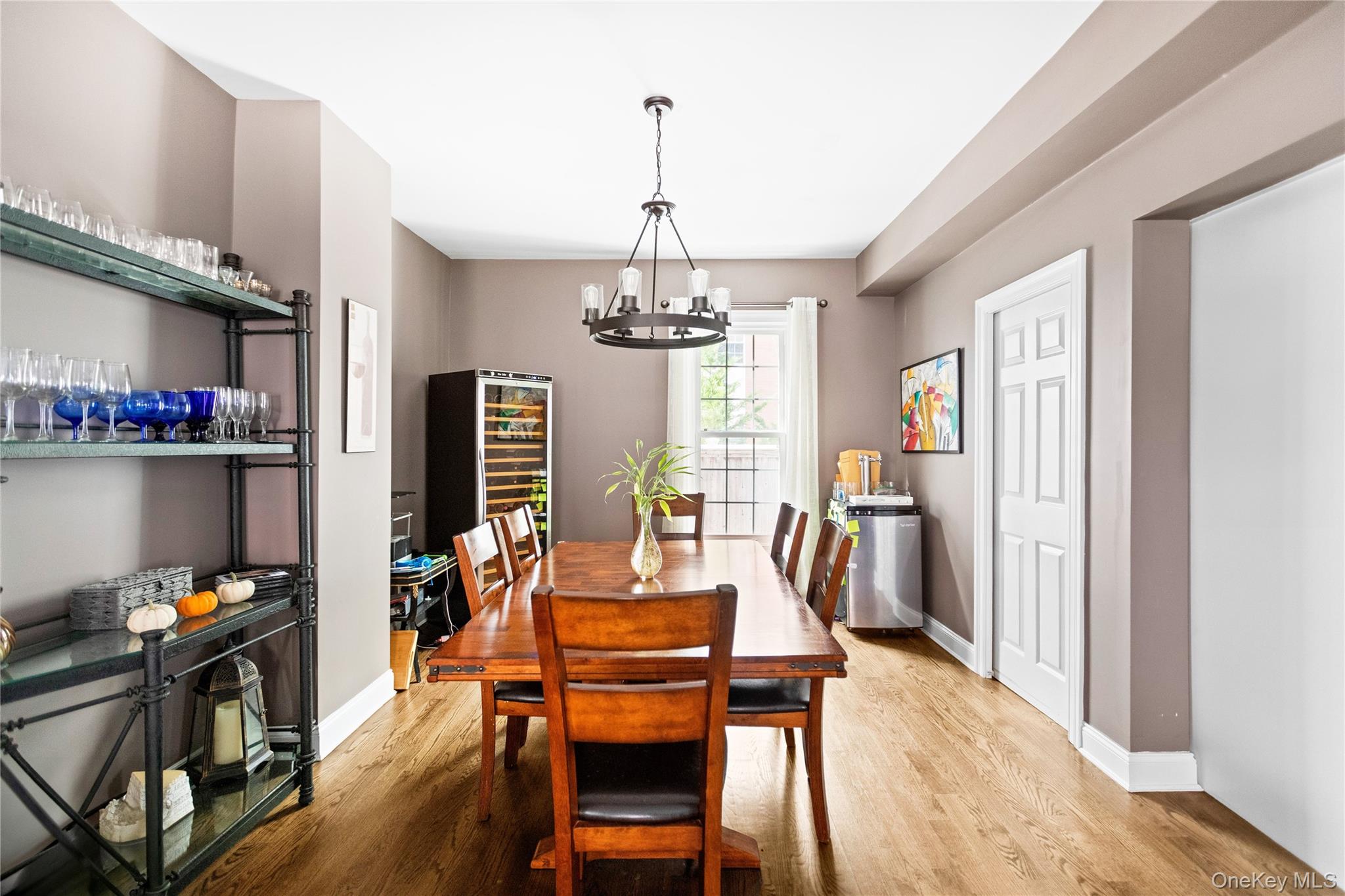 10 Maple Avenue Patchogue, NY 11772 - Photo 12 of 28 Dining area featuring light wood finished floors, wine cooler, and a chandelier