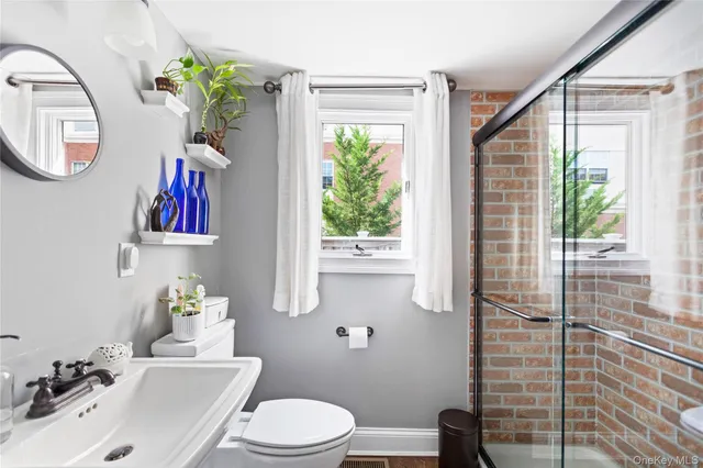 a bathroom with a toilet a sink and a large mirror
