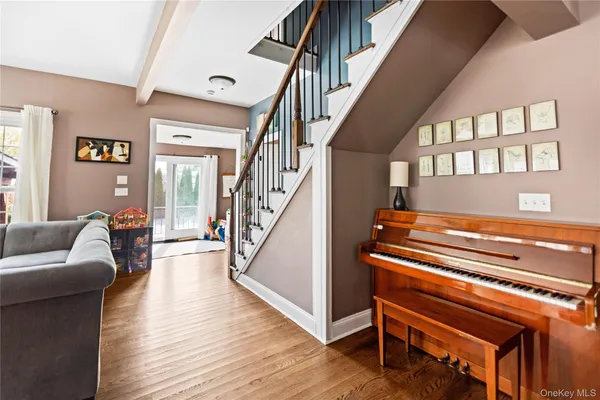 a living room with wooden floor furniture and a ceiling fan